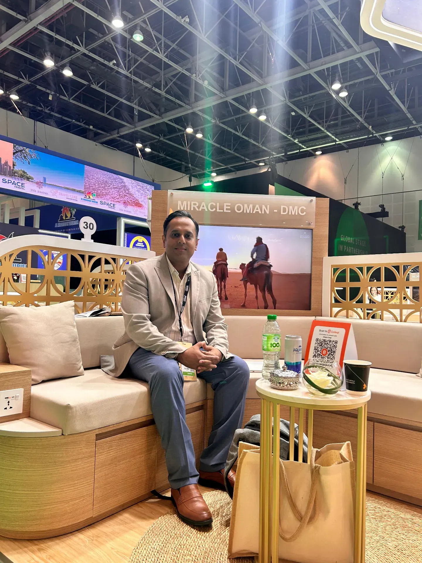 Team member seated at the Miracle Oman DMC stand