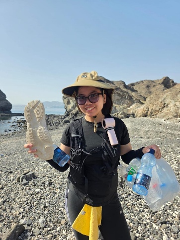 Team member holding collected rubbish on the beach