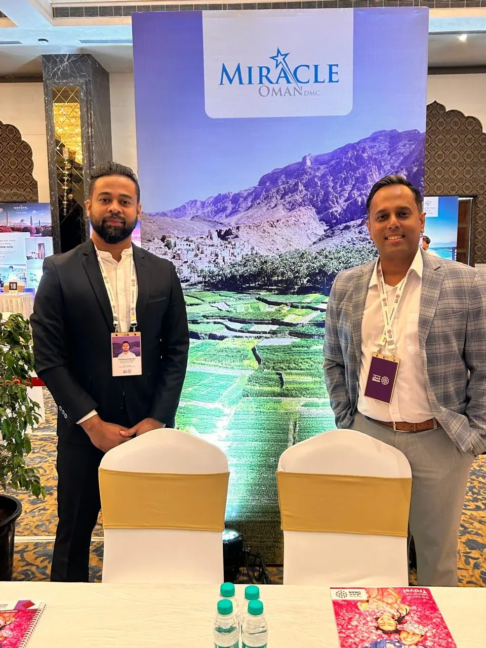 Representatives standing at a Miracle Oman travel exhibition stand