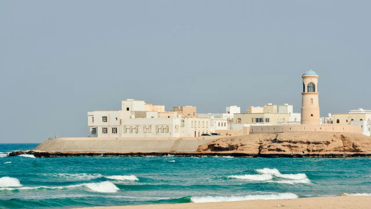 White coastal buildings and a minaret above turquoise sea